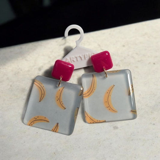 Ces Boucles d'oreilles Banane bleu transparentes de 5.5cm sont une touche élégante à votre tenue. Les clous plaqués or 18 carats ajoutent une touche de luxe à leur design unique. Faites une déclaration de mode avec ces boucles d'oreilles uniques.