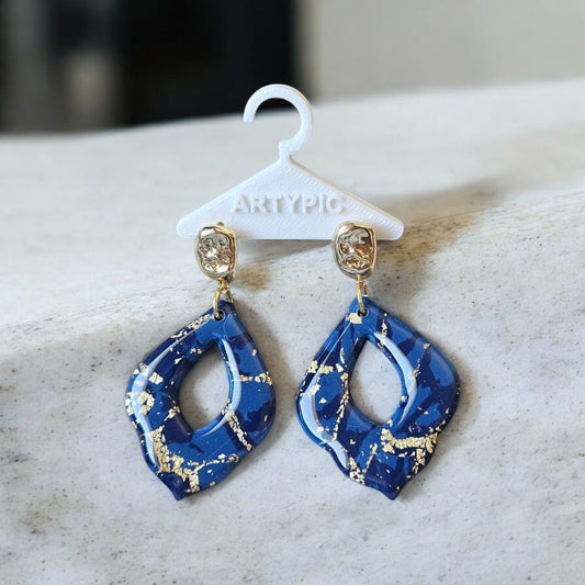 Ces boucles d'oreilles Galaxy élégantes ajoutent une touche de brillance à n'importe quelle tenue avec leur design en feuilles d'or et leur plaquage en or 24 carats. Un choix parfait pour se démarquer et ajouter une touche de luxe à votre style.