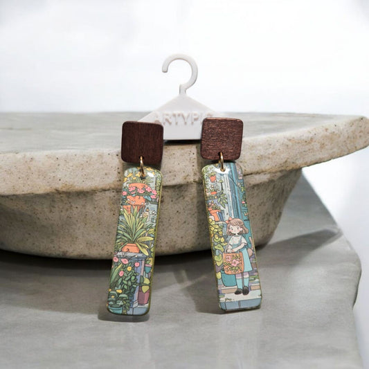 Ces boucles d'oreilles Kiki de 7 cm sont un accessoire élégant et moderne. Les clous en bois et les anneaux plaqués or 18 carats ajoutent une touche de sophistication à votre look. Profitez de leur longueur et de leur style pour mettre en valeur vos tenues.