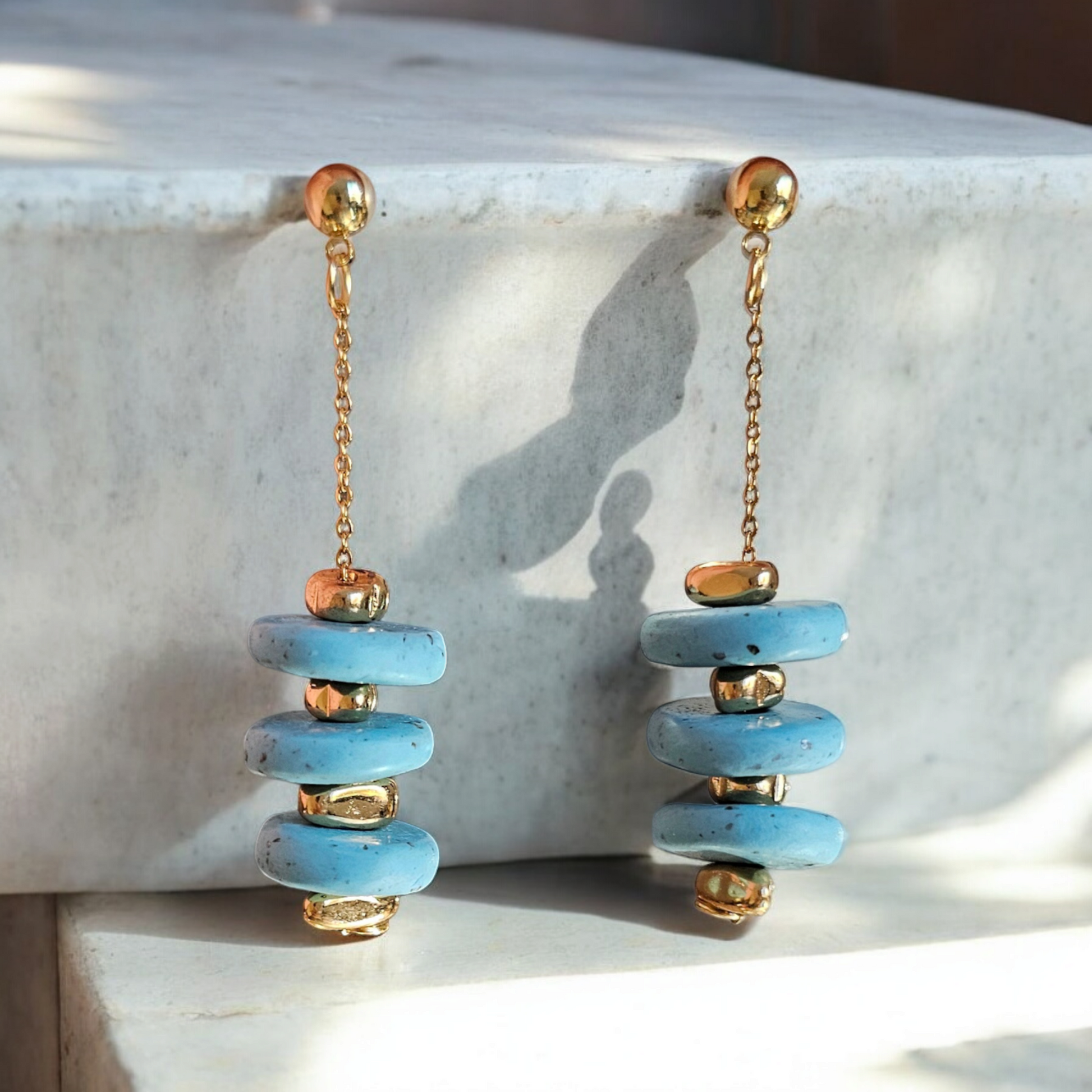 Ces boucles d'oreilles bleues en argile polymère apportent une touche de fantaisie à votre tenue. Avec son effet turquoise et sa chaîne en plaqué or 18 carats, elles mesurent 5,5 cm de longueur.