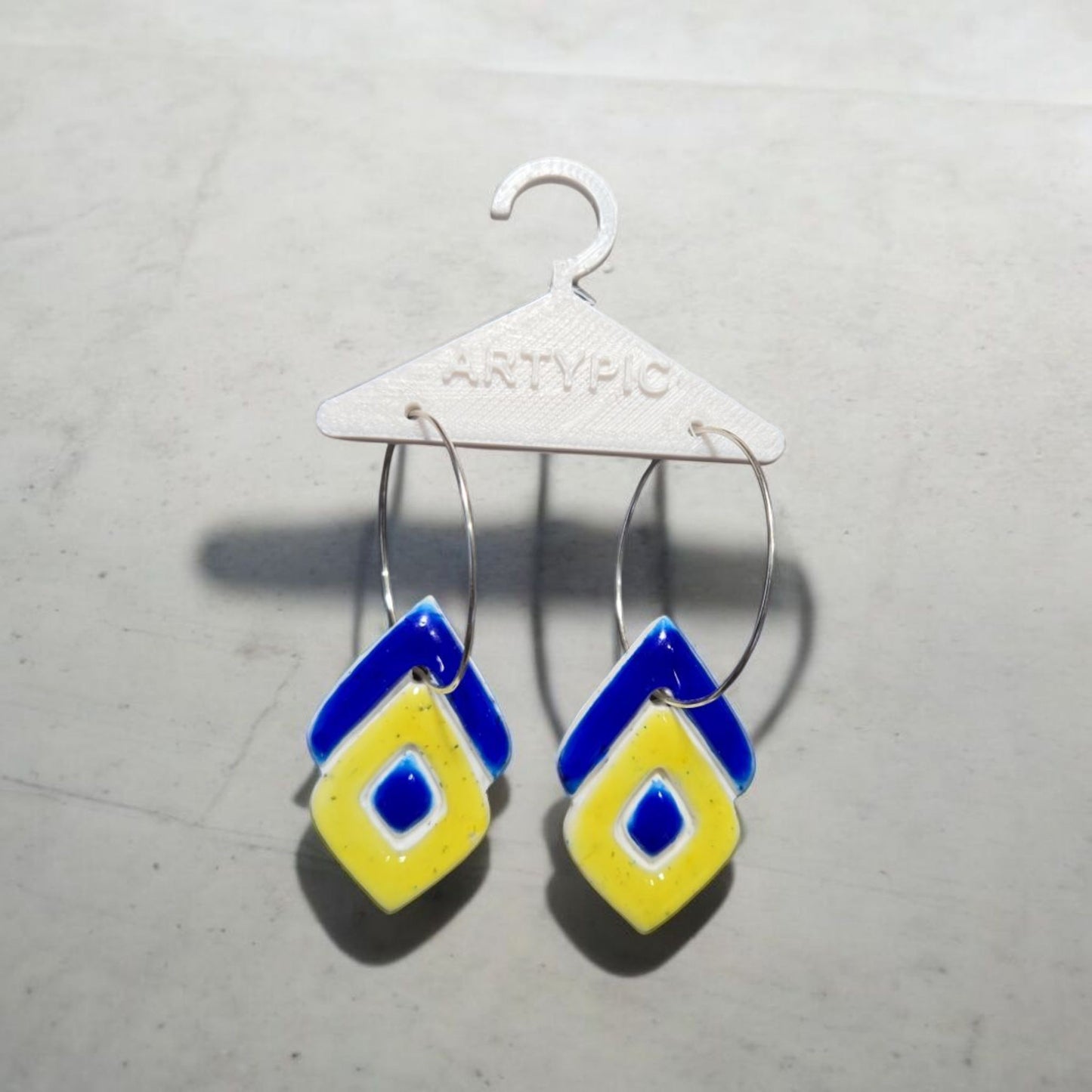 Les boucles d'oreilles Nola 5,5 cm sont ornées de sable de l'étang salé de lîle de la Réunion. Les cristaux de sable apportent une touche unique et naturelle à ces boucles d'oreilles élégantes. Parfait pour ajouter une touche de voyage et de nature à votre tenue.