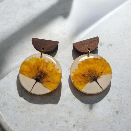 Les boucles d'oreilles Madeleine vous apportent une touche de naturel avec leurs fleurs véritables. Avec une longueur de 5,2cm et des clous en acier inoxydable, elles sont à la fois élégantes et résistantes. Parfaites pour ajouter une touche de charme à votre tenue.