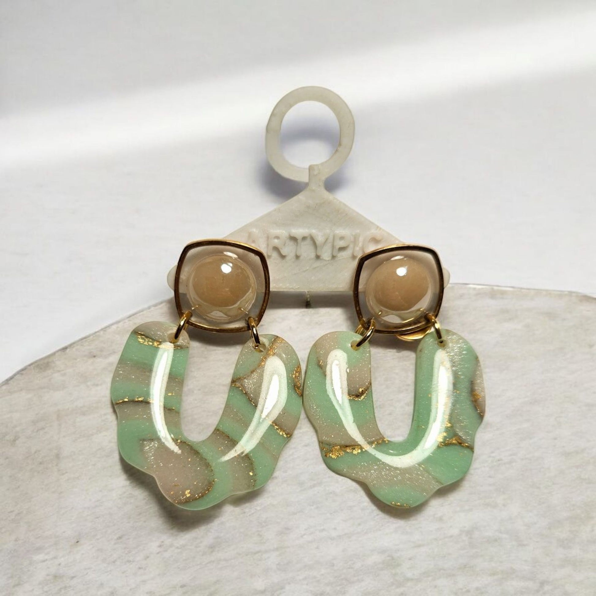 Les boucles d'oreilles Romane sont des bijoux délicats et élégants, ornés de perles vertes et roses. Avec une longueur de 5cm, elles sont parfaites pour ajouter une touche de couleur à votre tenue. Les tiges plaquées or 18 carats assurent une qualité durable pour ces boucles d'oreilles raffinées. Un ajout indispensable à votre collection de bijoux.