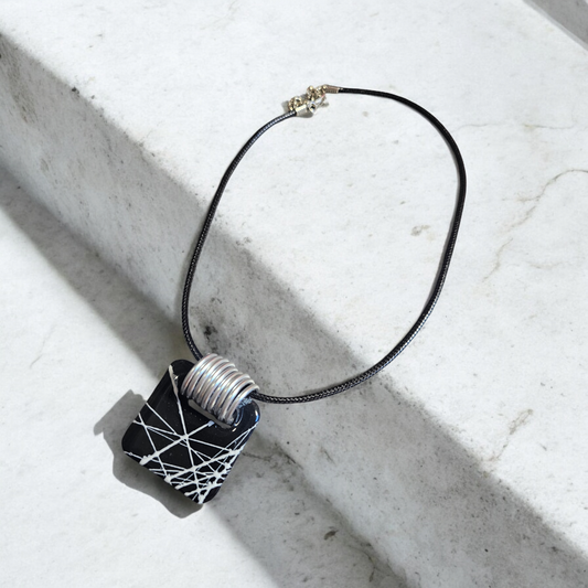 collier en argile polymère noir avec ses traits blancs rappelant la beauté des toiles de la Babouk de l'île de la Réunion. Avec ses dimensions de 3,7 x 3,7 cm
