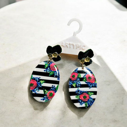 Ces boucles d'oreilles Lilou 2 de 6cm sont entièrement peintes à la main, ajoutant ainsi une touche unique à votre look. Les clous en acier inoxydable assurent une durabilité et un confort.