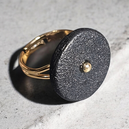  bague Lima noire est l'accessoire parfait pour compléter votre tenue. Fabriquée en argile polymère mate noire, elle est à la fois élégante et moderne. Son anneau réglable en plaqué or 24 carats vous assure un ajustement parfait. 