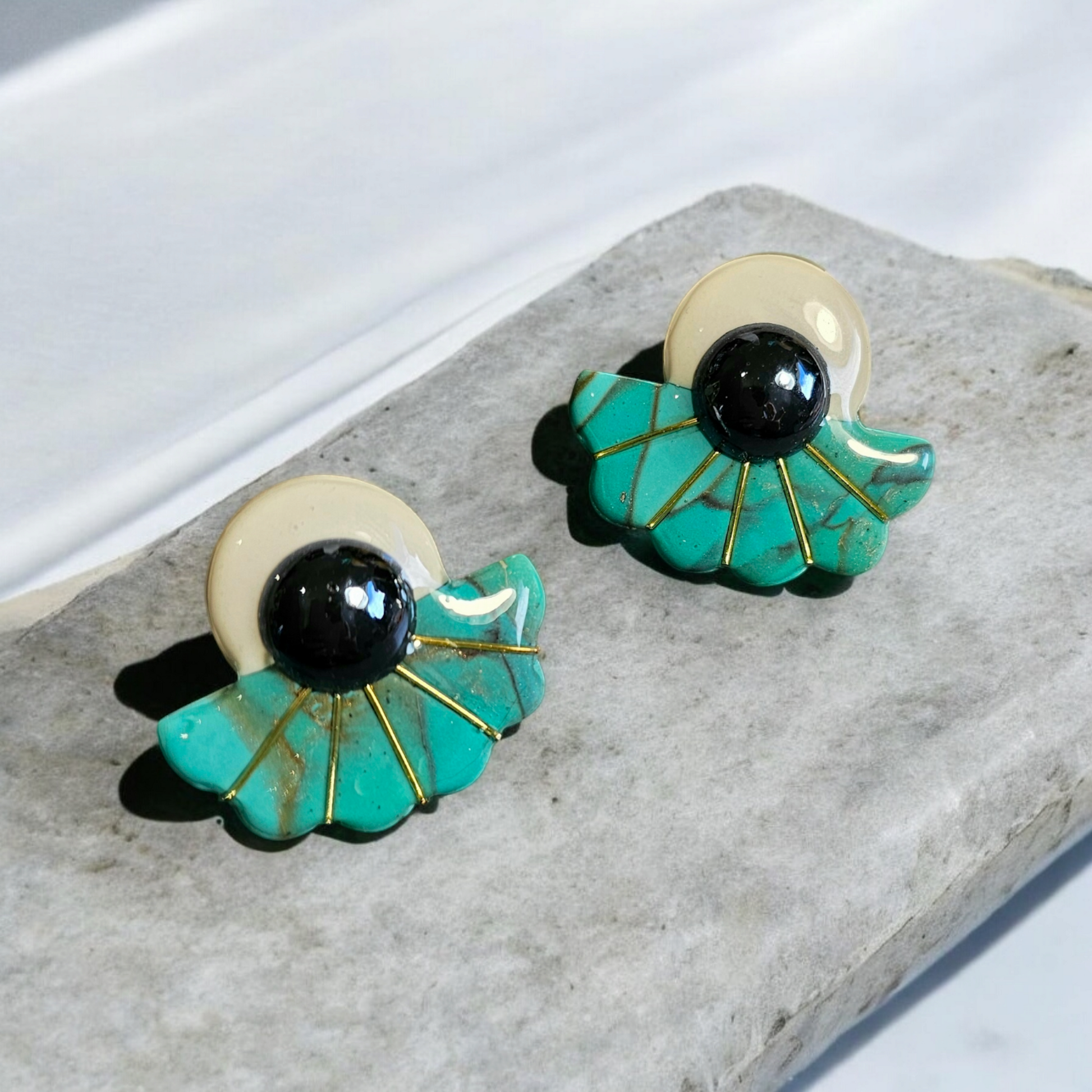 Ces boucles d'oreilles Riva en argile polymère bleu turquoise et blanc sont ornées de tiges plaquées or 18k pour une longueur totale de 2,8 cm. Apportez de la couleur et de l'élégance à votre tenue avec ces accessoires uniques et de qualité.