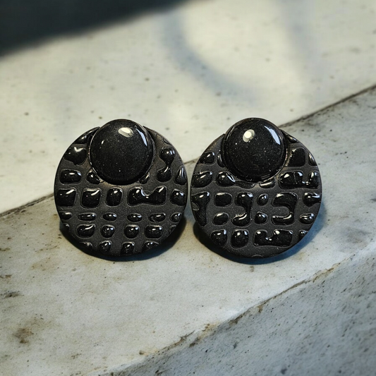 Boucles d'oreilles en argile polymère noires "Sydney" avec tiges en acier inoxydable. Légères et élégantes, elles ajoutent une touche moderne à vos tenues. Longueur totale de 3,2 cm pour une allure raffinée.